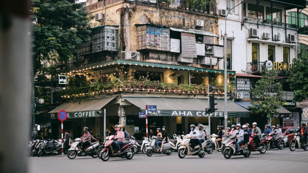 Busy street in Hanoi Old Quarter with motorbikes and colonial buildings